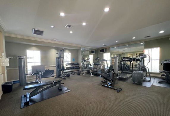 Indoor gym area with exercise equipment including treadmills and weight machines.