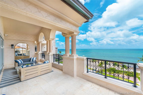 Terrace with elegant railing and decorative columns, overlooking the ocean.
