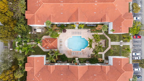 Aerial view of a complex with a central swimming pool surrounded by buildings.