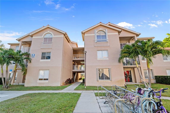 Front view of a three-story apartment building with balconies.