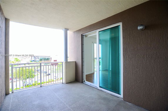 Balcony view with sliding glass doors and railing, overlooking surrounding area.