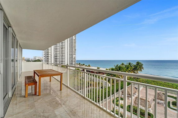 View of a building's balcony overlooking the ocean and surrounding areas.
