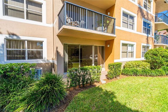 Front view of a multi-story residential building with balconies and large windows.