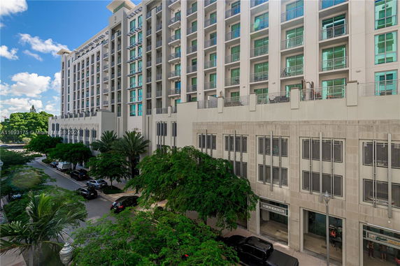 Front view of a multi-story building with balconies and large windows.