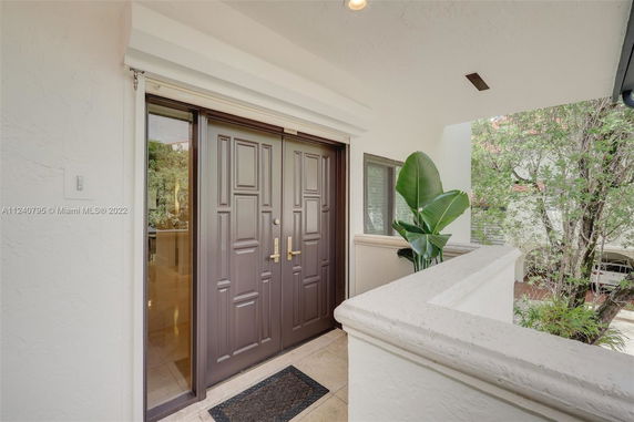 Front entrance of a house with double doors and a small window beside it.