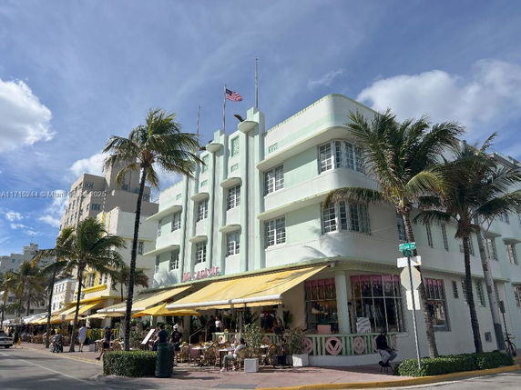 Front view of a multi-story building with a distinctive art deco style and yellow awnings.