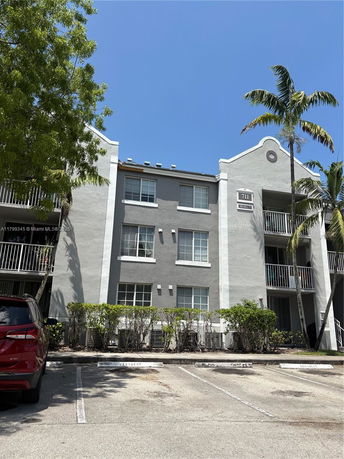 Front view of a three-story apartment building with balconies on the side.