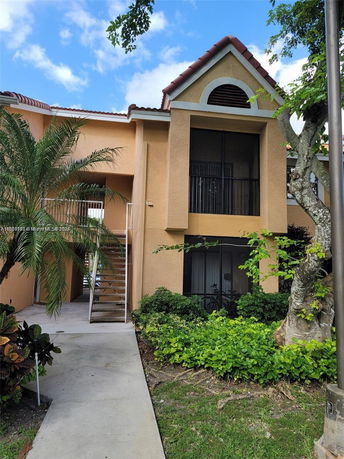 Front view of a two-story house with a stairway entrance and tiled roof.