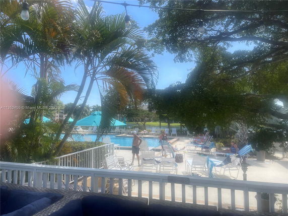 Outdoor swimming pool area with lounge chairs and umbrellas.