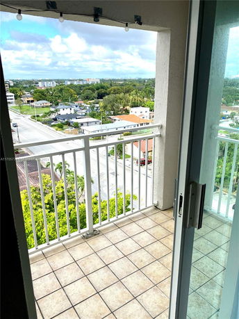 Panoramic view from a balcony showing surrounding buildings and landscape.