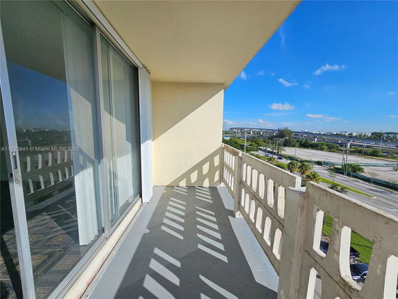 Balcony of a building with a view of surrounding roads and greenery.