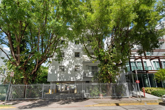 Front view of a multi-story building with a gated entrance.