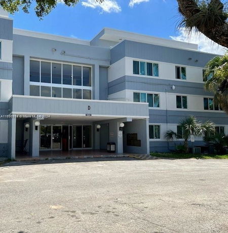Front view of a three-story building with large windows and an entrance canopy.