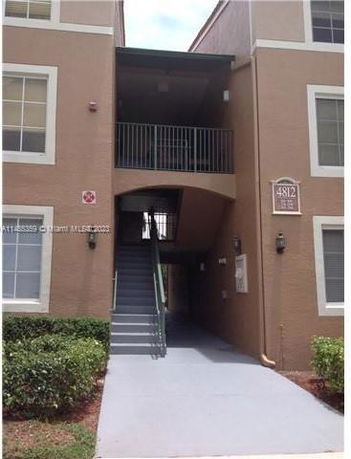 Front view of a multi-story apartment building with a staircase and balcony.