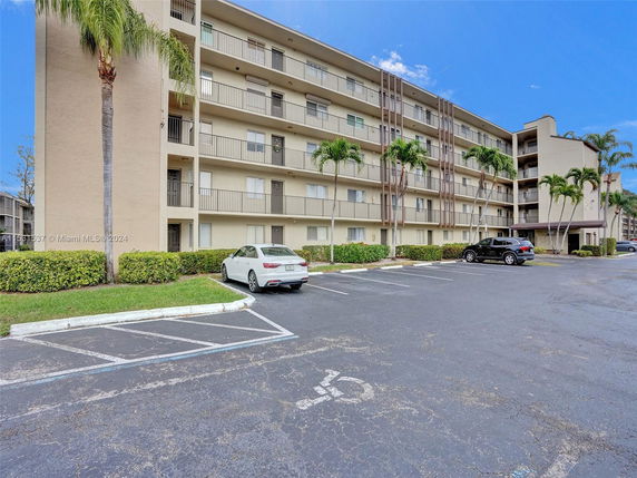 Front view of a multi-story apartment building with balconies.
