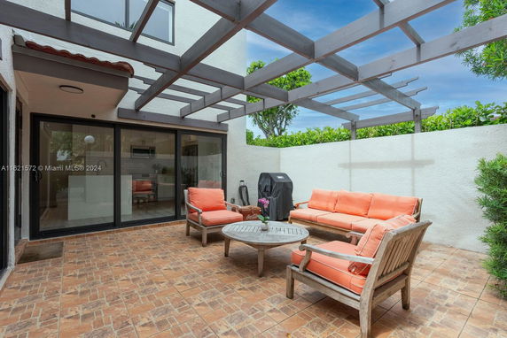 Outdoor patio area with seating and partial pergola overhead.