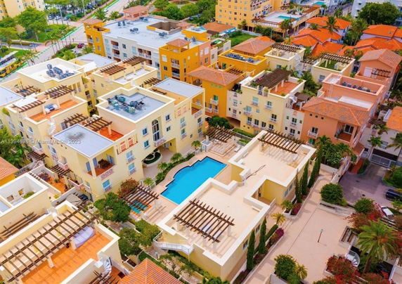 Aerial view of residential buildings with flat rooftops featuring pergolas and air conditioning units.