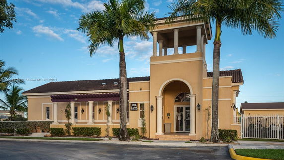 Front view of a building with columns and an upper balcony area.