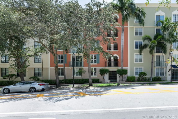 Front view of a multi-story building with balconies and large windows.