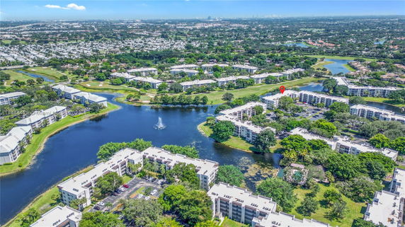 Aerial view of residential complex surrounded by water bodies and greenery.