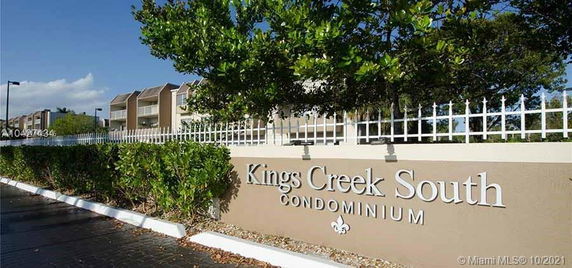 Front view of a condominium complex with a sign reading 'Kings Creek South.'
