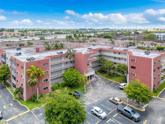 Front view of a multi-story residential building with red exterior and balcony railings.