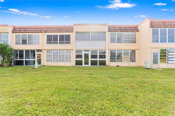 Front view of a two-story building with large windows and a flat roof.