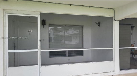 Front view of an apartment with a screened porch area.