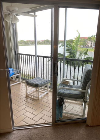 View from a balcony overlooking a body of water and distant buildings.