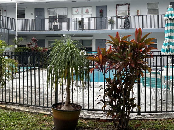 Outdoor swimming pool area with surrounding residential building.