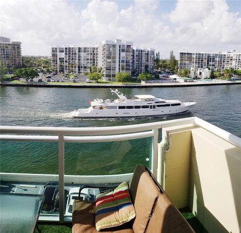 View from a balcony overlooking a waterway with buildings in the background.