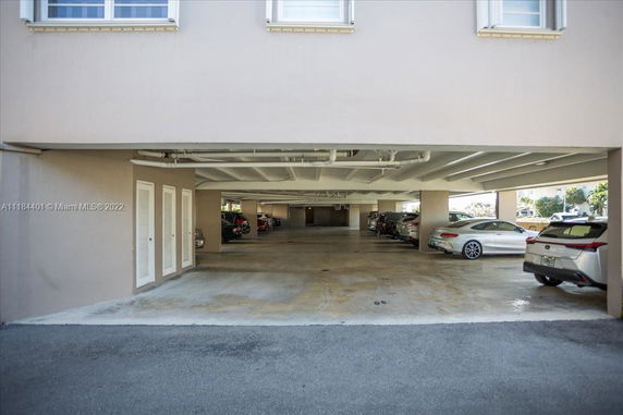 Front view of a building with an open parking area underneath.