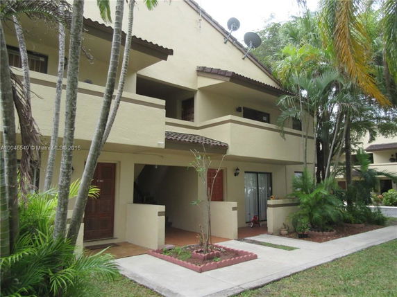 Front view of a two-story house with balconies and a sloped roof.