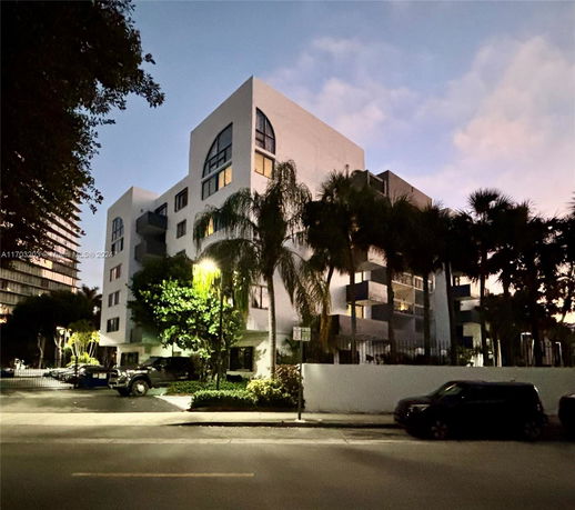 Front view of a multi-story building with unique arched windows.