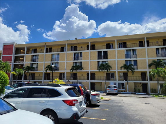 Front view of a four-story residential building with balconies.