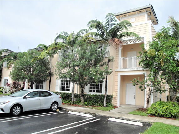 Front view of a two-story house with a balcony and white framed windows.