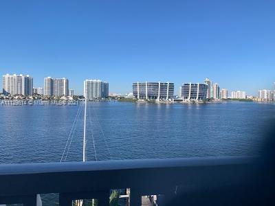 Panoramic view of a water body with several high-rise buildings in the background.