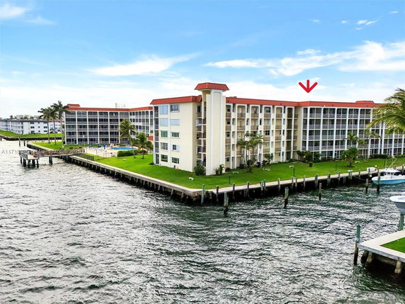Front view of a multi-story waterfront building with a red roof.