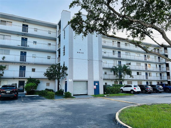 Front view of a multi-story apartment building with balconies.