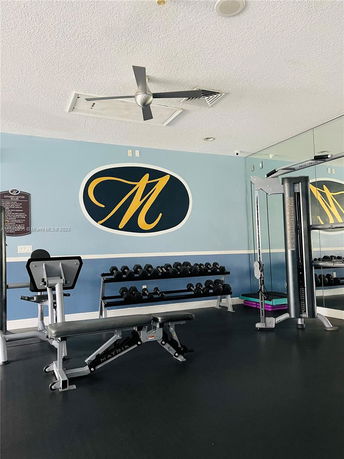 Indoor gym area with weights and exercise equipment.