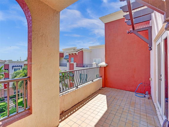 Outdoor view from a balcony overlooking adjacent multi-story buildings.