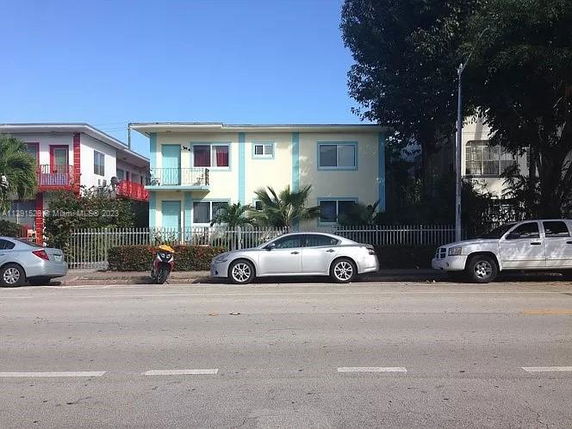 Front view of a two-story building with a light blue and yellow facade.