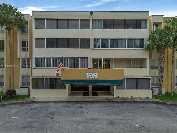 Front view of a multi-story building with a central entrance and balconies.