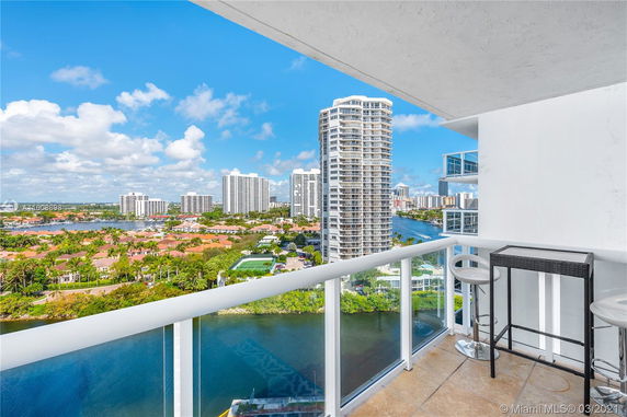Panoramic view from a balcony overlooking a cityscape with high-rise buildings and waterways.