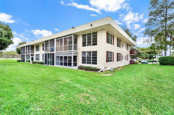 Front view of a two-story building with large windows and a flat roof.