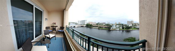 Wide-angle view of a balcony overlooking a waterway with buildings in the background.