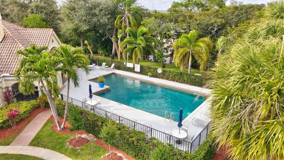 Outdoor swimming pool with surrounding greenery and seating areas.