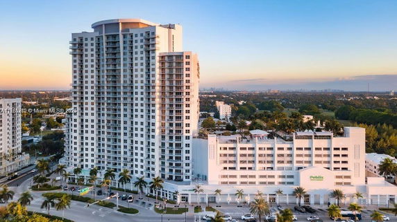 Front view of a high-rise residential building with adjacent parking structure.