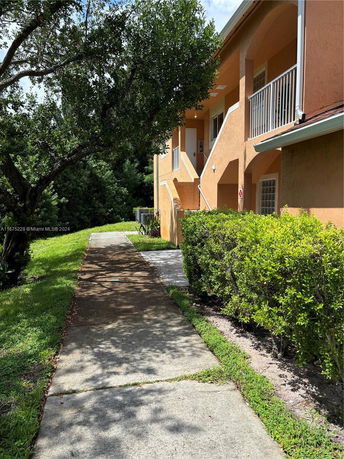 Side view of a two-story building with orange exterior and external stairs.