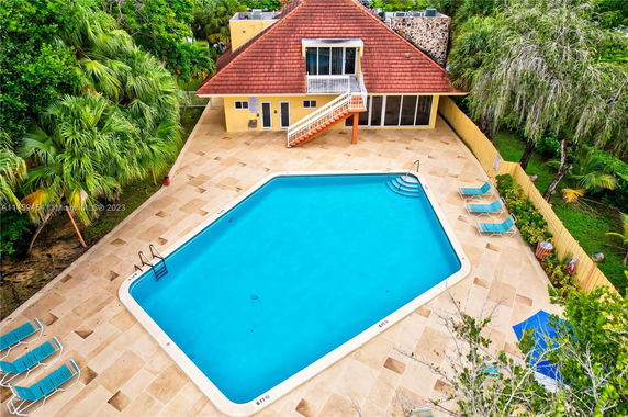 Aerial view of a swimming pool area with a building in the background.